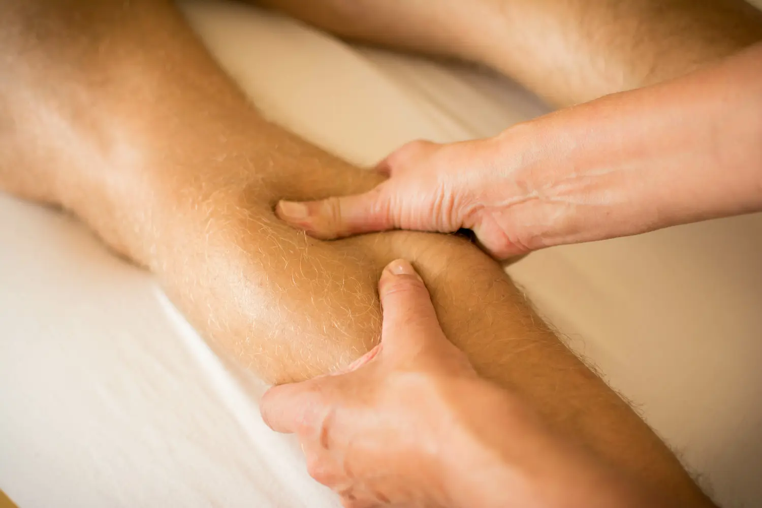Therapeut übt Druck auf das männliche Bein aus – Handmassage des menschlichen Wadenmuskels